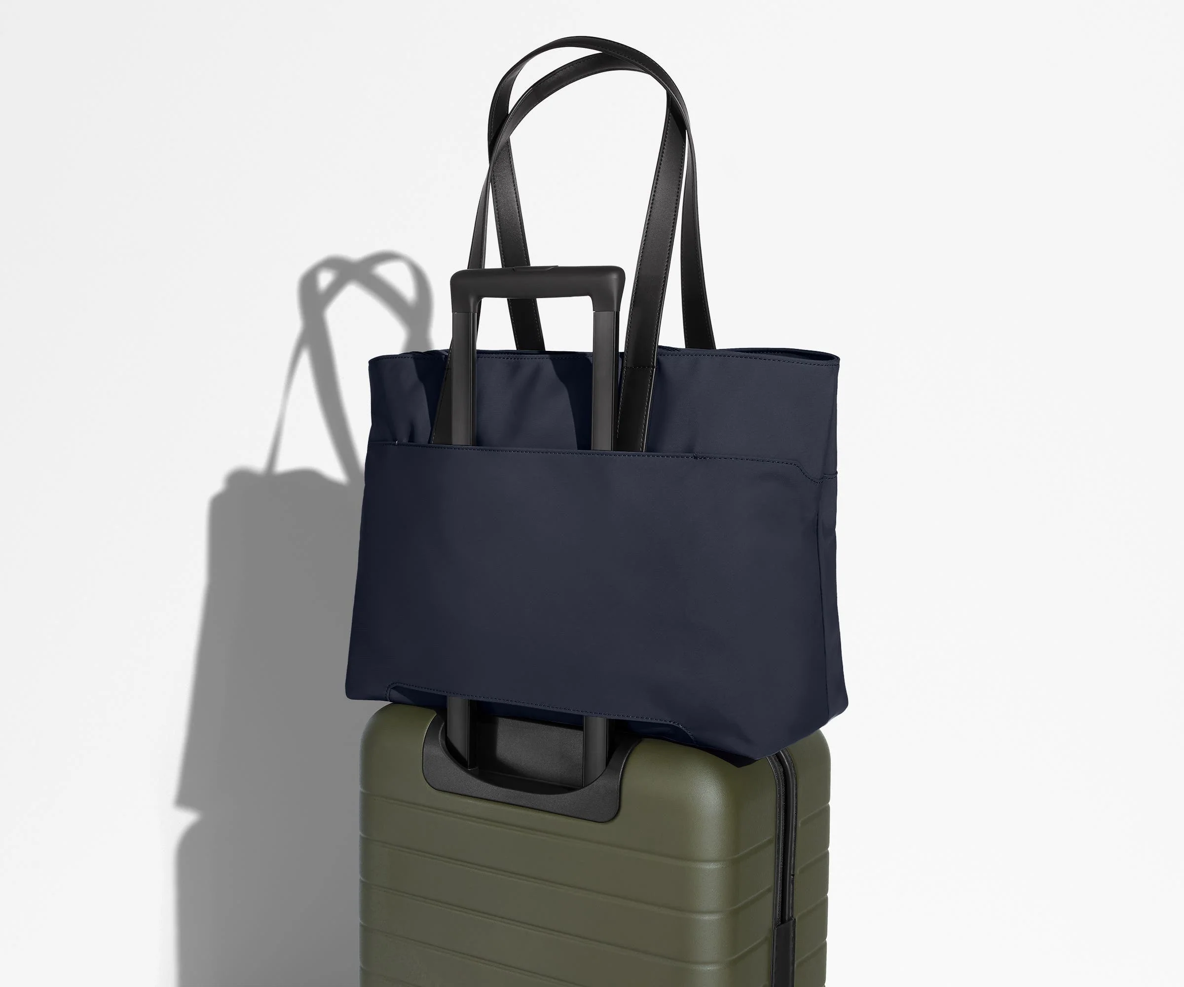 Everywhere Tote secured to an Away suitcase by its trolley sleeve