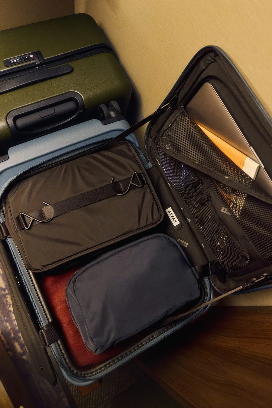 Open suitcase with various items inside on a wooden surface